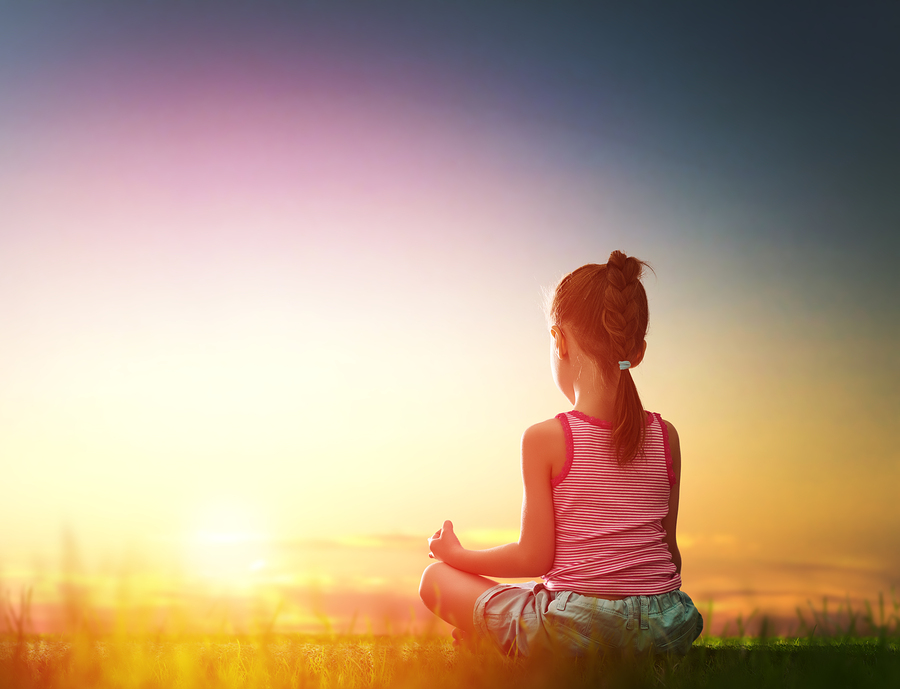 Child girl in the Park. Yoga at sunset in the park. Girl is prac